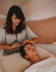 Caroline Duhau, praticienne Head Spa, en train de réaliser un soin du cuir chevelu sur une cliente.