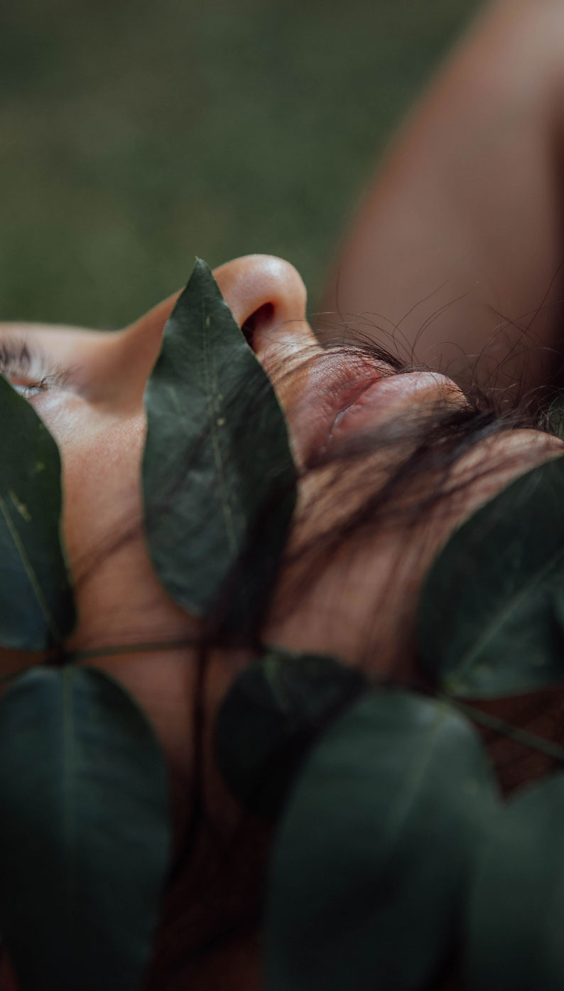 Jeune femme allongée en pleine nature, les yeux tournés vers le ciel
